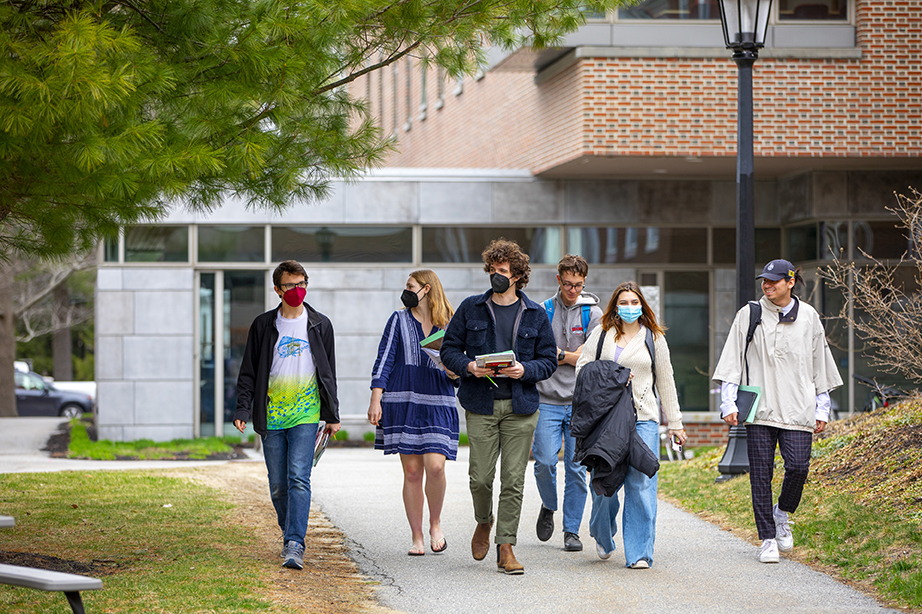 Six students walking together outside through the campus.