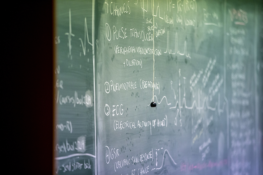 A shot of a green chalkboard with medical notes written on it in white chalk.