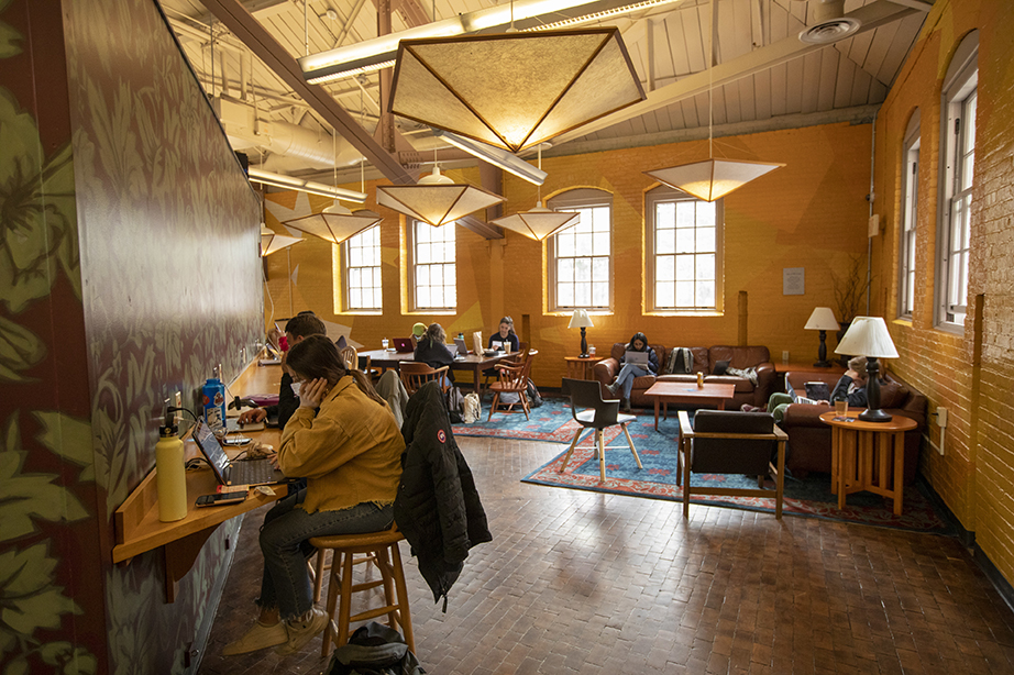 Students sitting in a well-lit, upstairs study area in Smith Union.