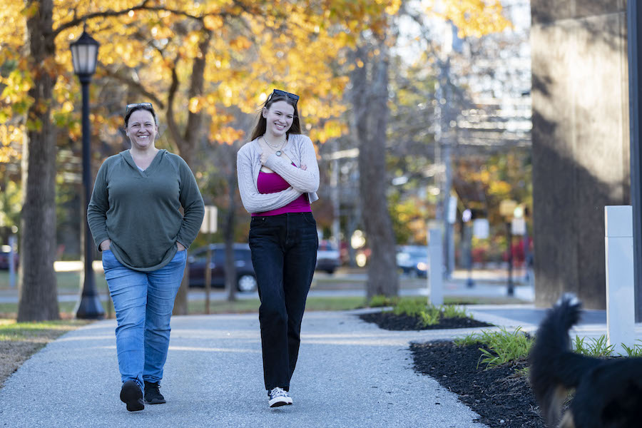 A student walks with a relative across campus