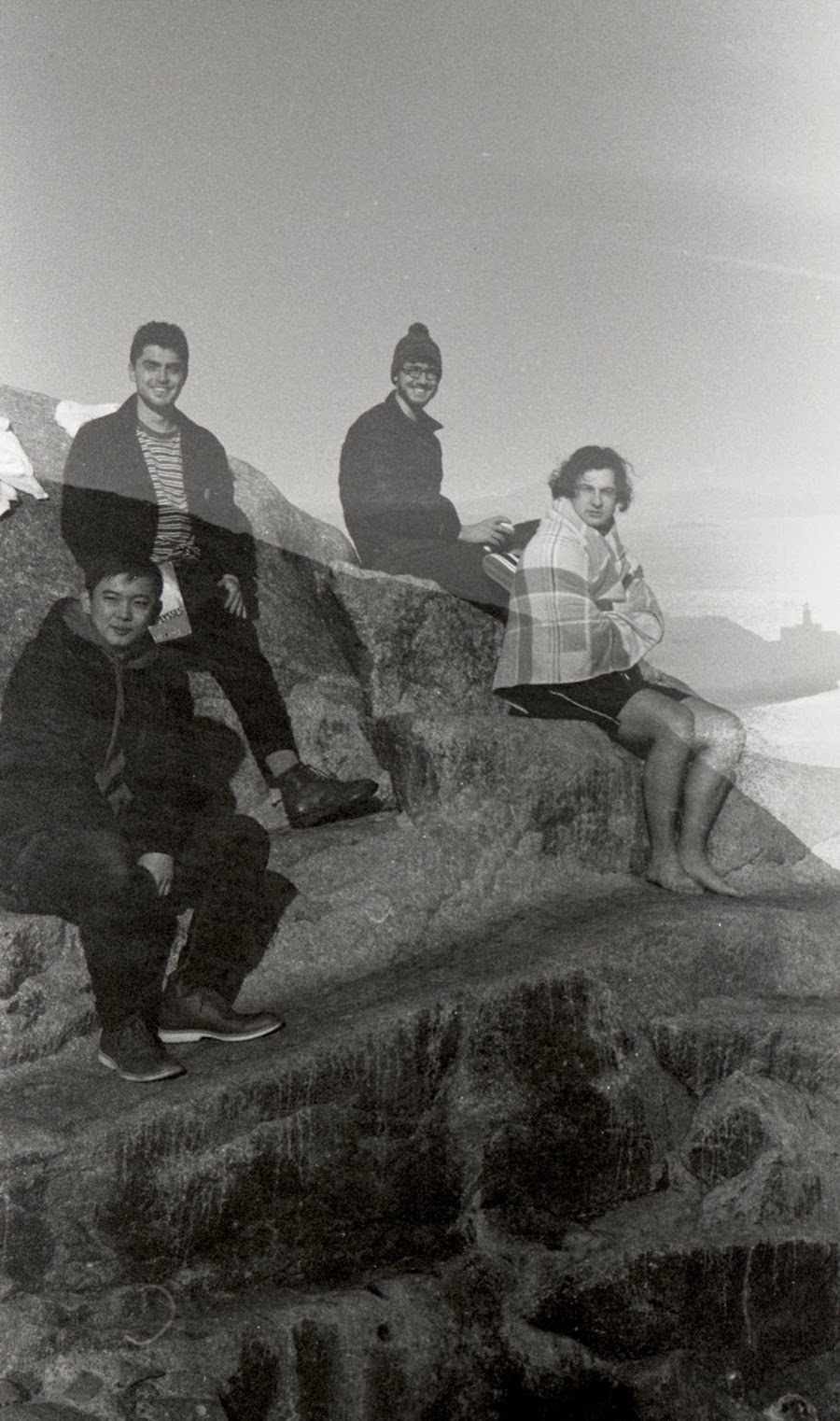 Students sitting on a rock after a swim