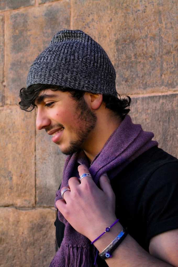 Khalil Kilani modeling a hat and scarf that will support small Peruvian mountain villages