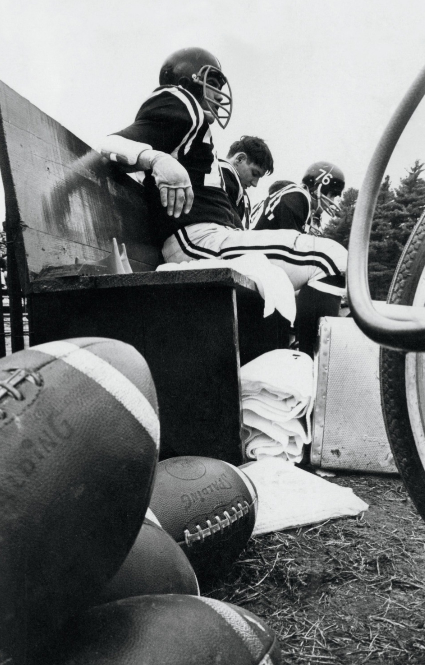 Bowdoin football players loom large on the Whittier Field sideline (undated photo).