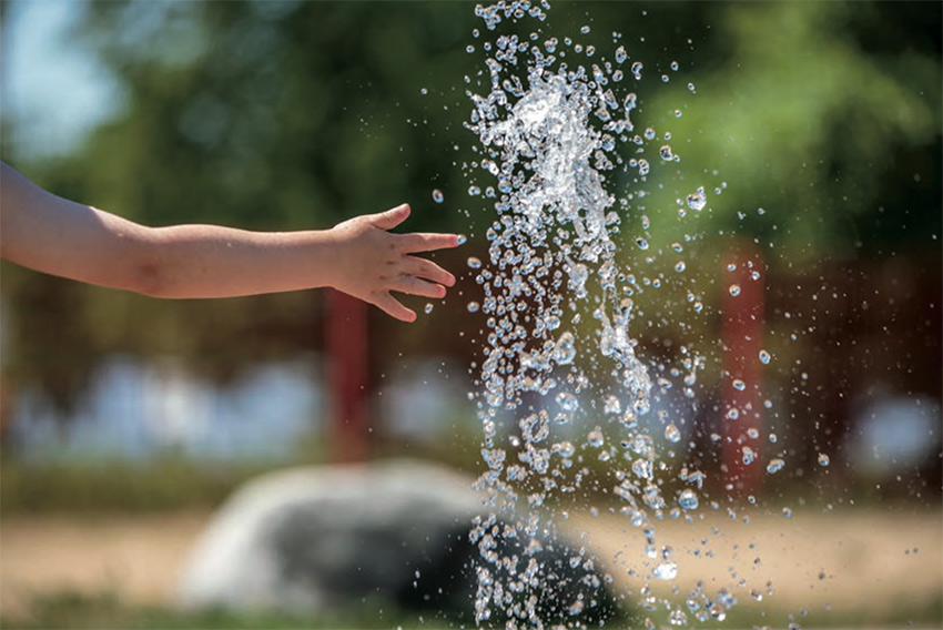 Hands splashing in a water fountain