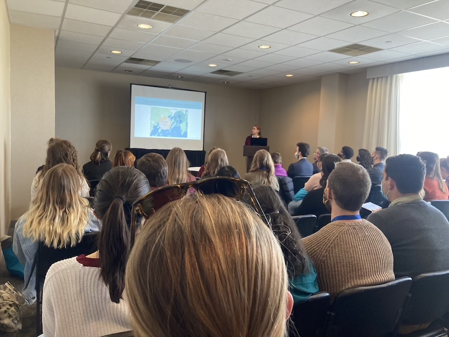 Student gives a talk in a packed room