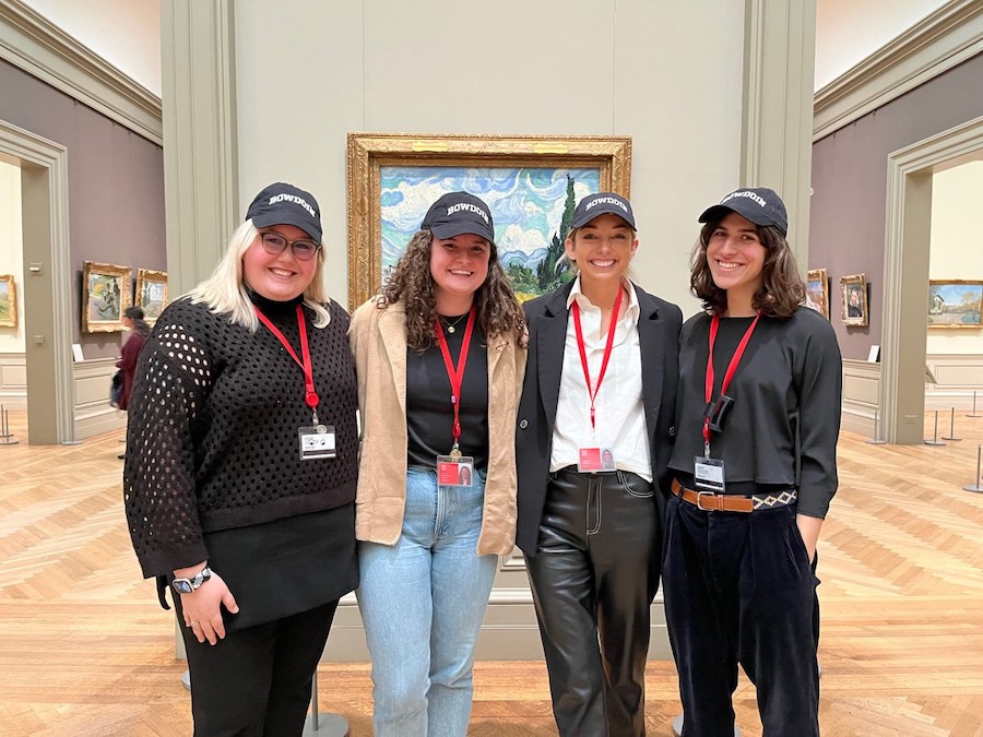 Alumni hosts in front of a Van Gogh in Bowdoin ballcaps
