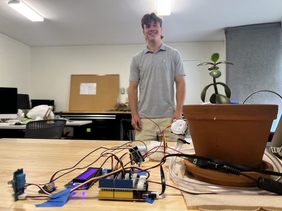 Ben stands behind his plant and monitoring system