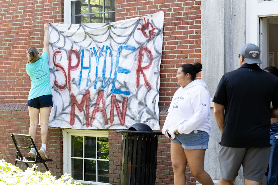 Students hang a sheet with "shyder hall" on it