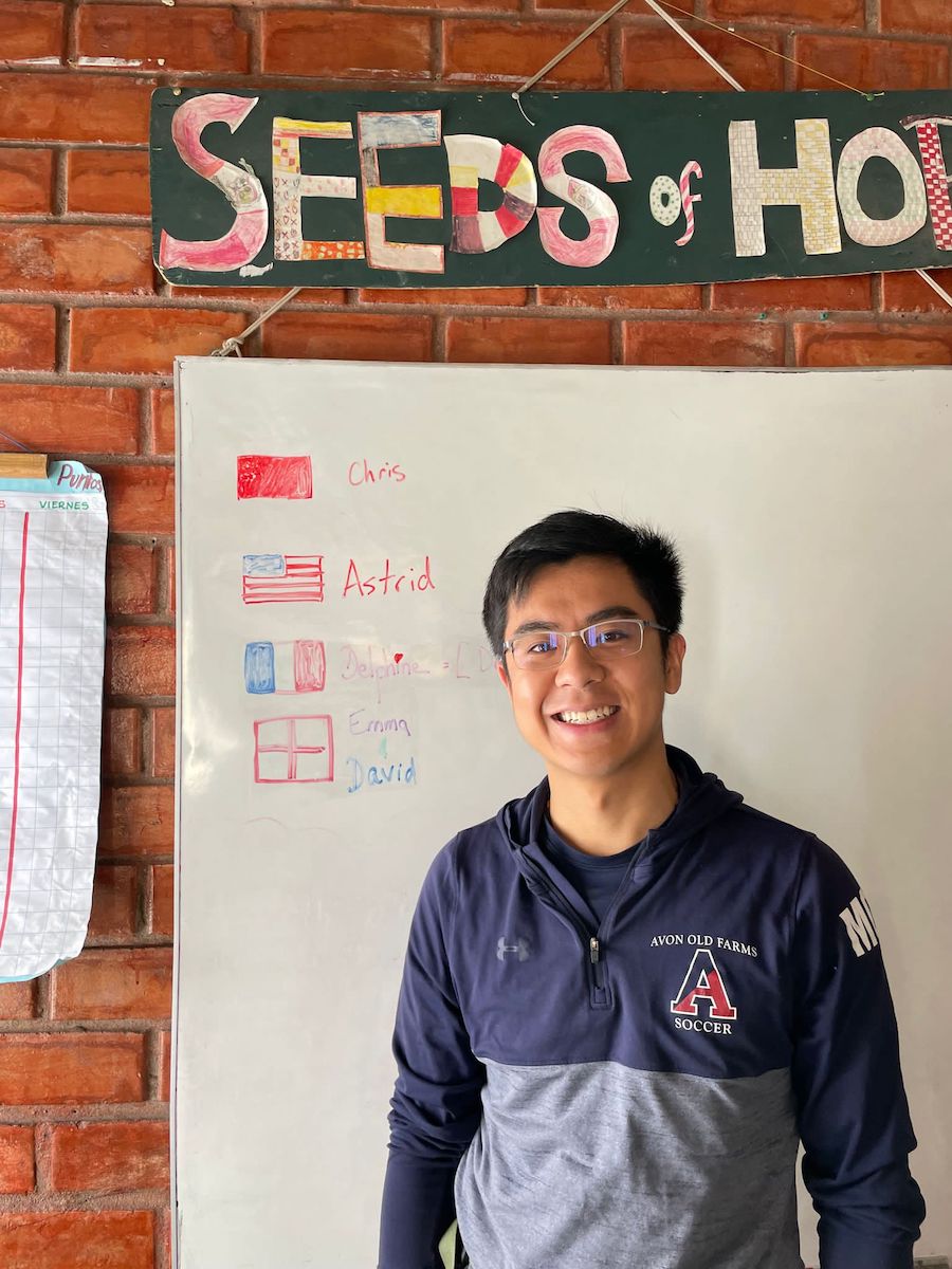 Chris Zhang in front of a Seeds of Hope poster