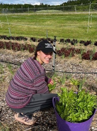 Neena Goldthwaite ’24 in a field of vegetables