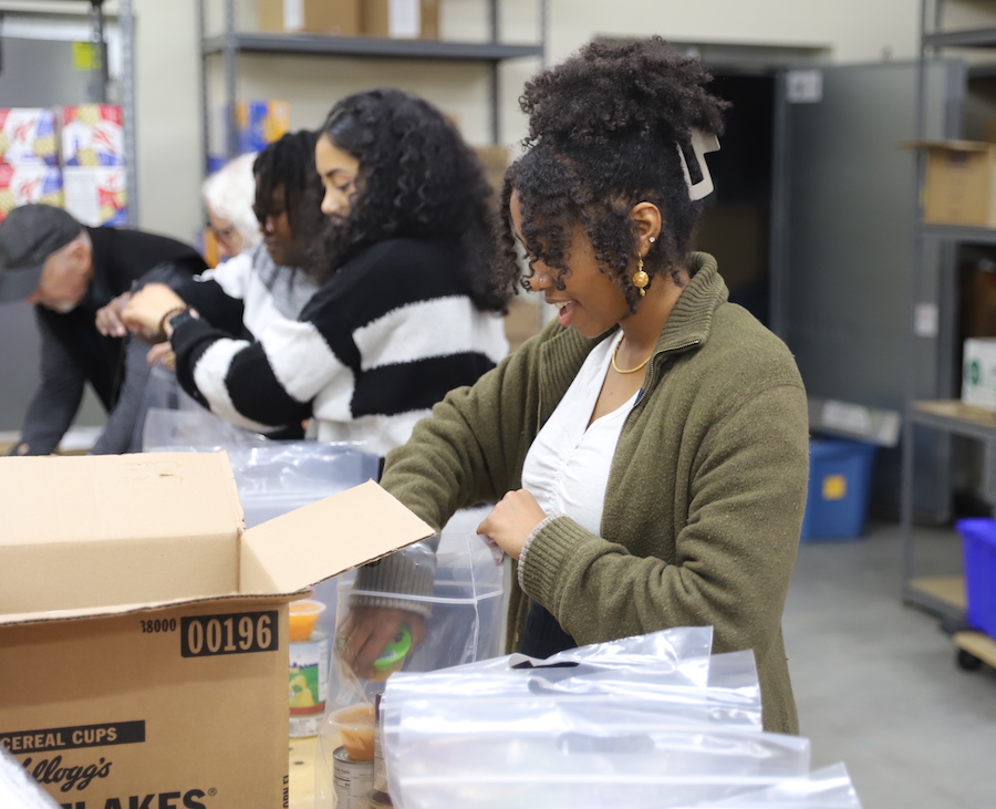 Karren Akwei ’24, Karen Gonzalez ’25, and Amal Mohamed ’27 at the food pantry, packing bags for students