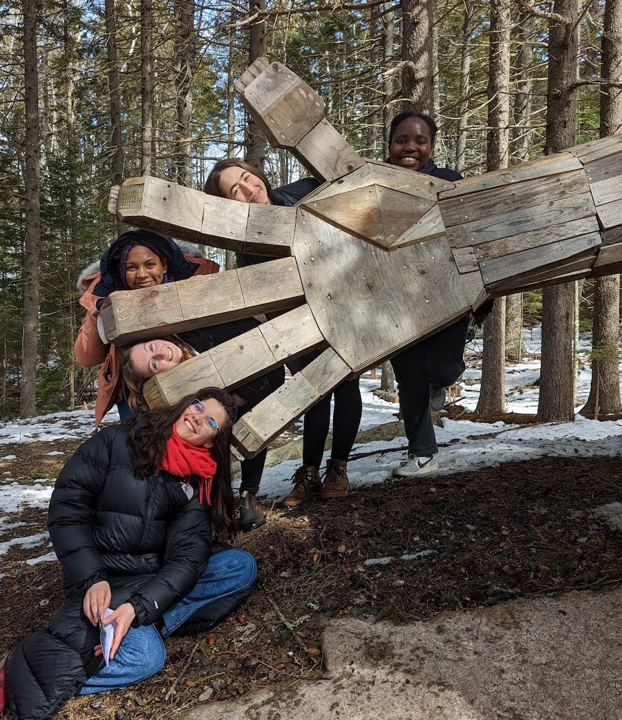 Students on the wellness retreat pose with a troll at the botanical gardens