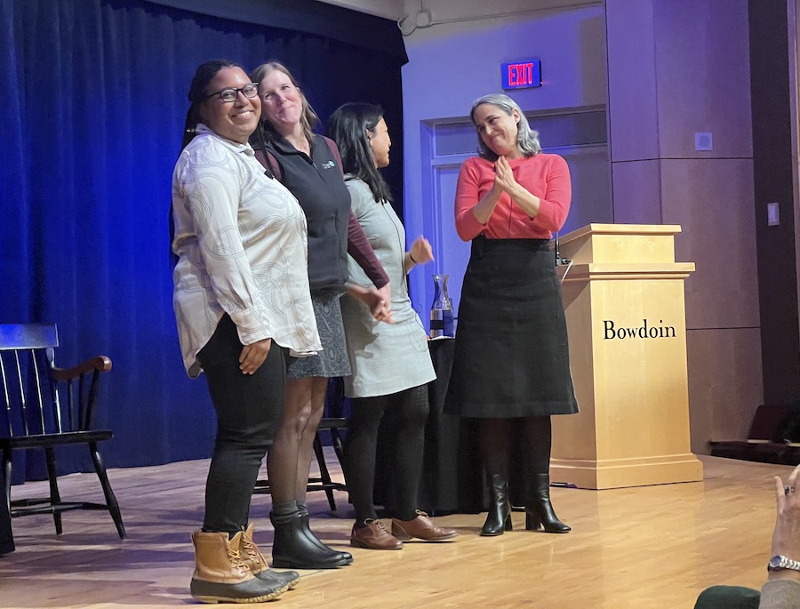 The three panelists and moderator on stage