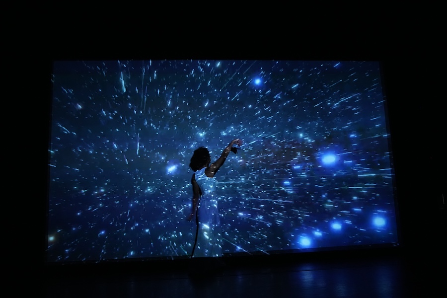 Dylan dances in front of star projection