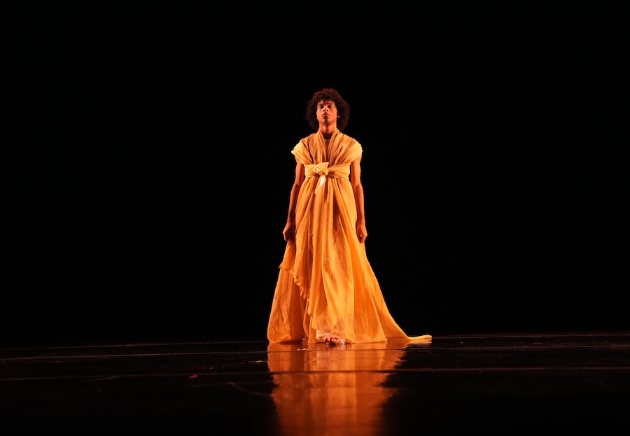 Dylan Richmond dances on stage in yellow fabric