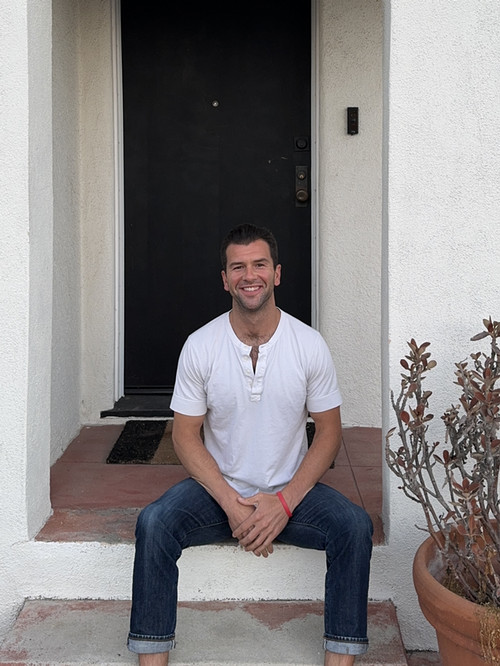 eric thompson '11 sitting on doorstep