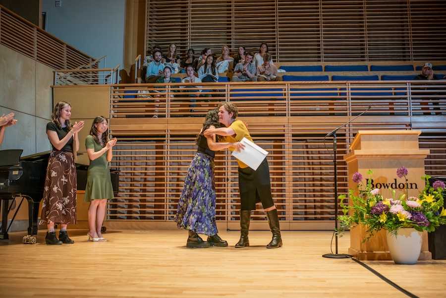 Ingrid Nelson hugs a student receiving a prize