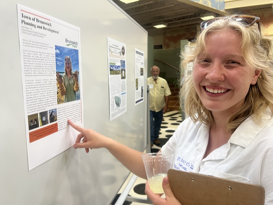 Student points to her own poster