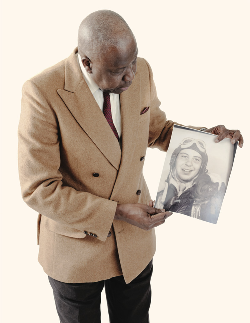 Mor Sene, holding a photo of Davidson as an Air Force gunner serving in the Pacific during World War II.