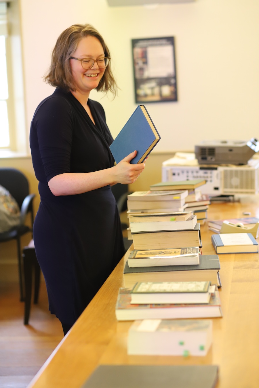 Maggie Solberg hands out books in Beowulf, an English class she taught this semester.