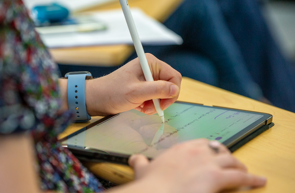 A Bowdoin student using an iPad in class.