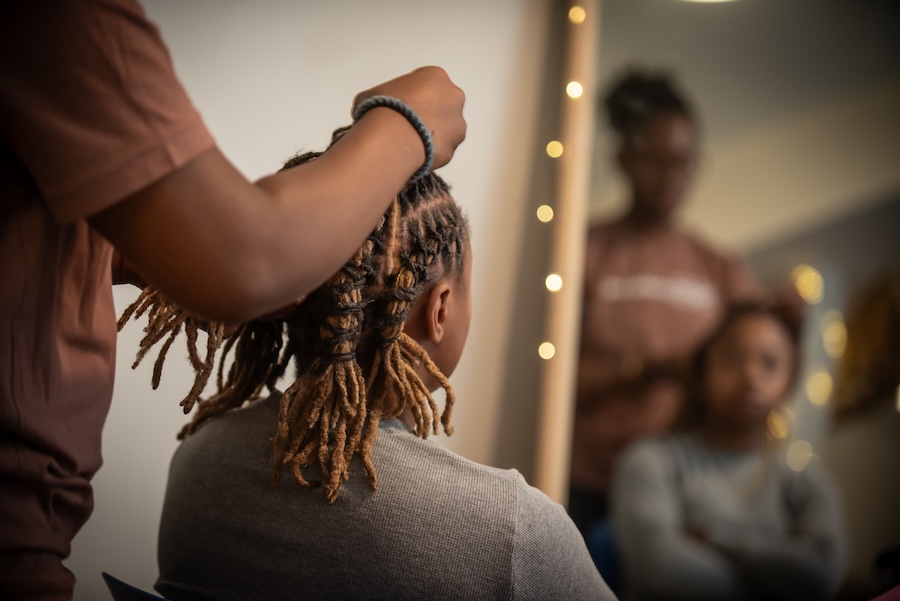 Glam and Glow, a student gets their hair done