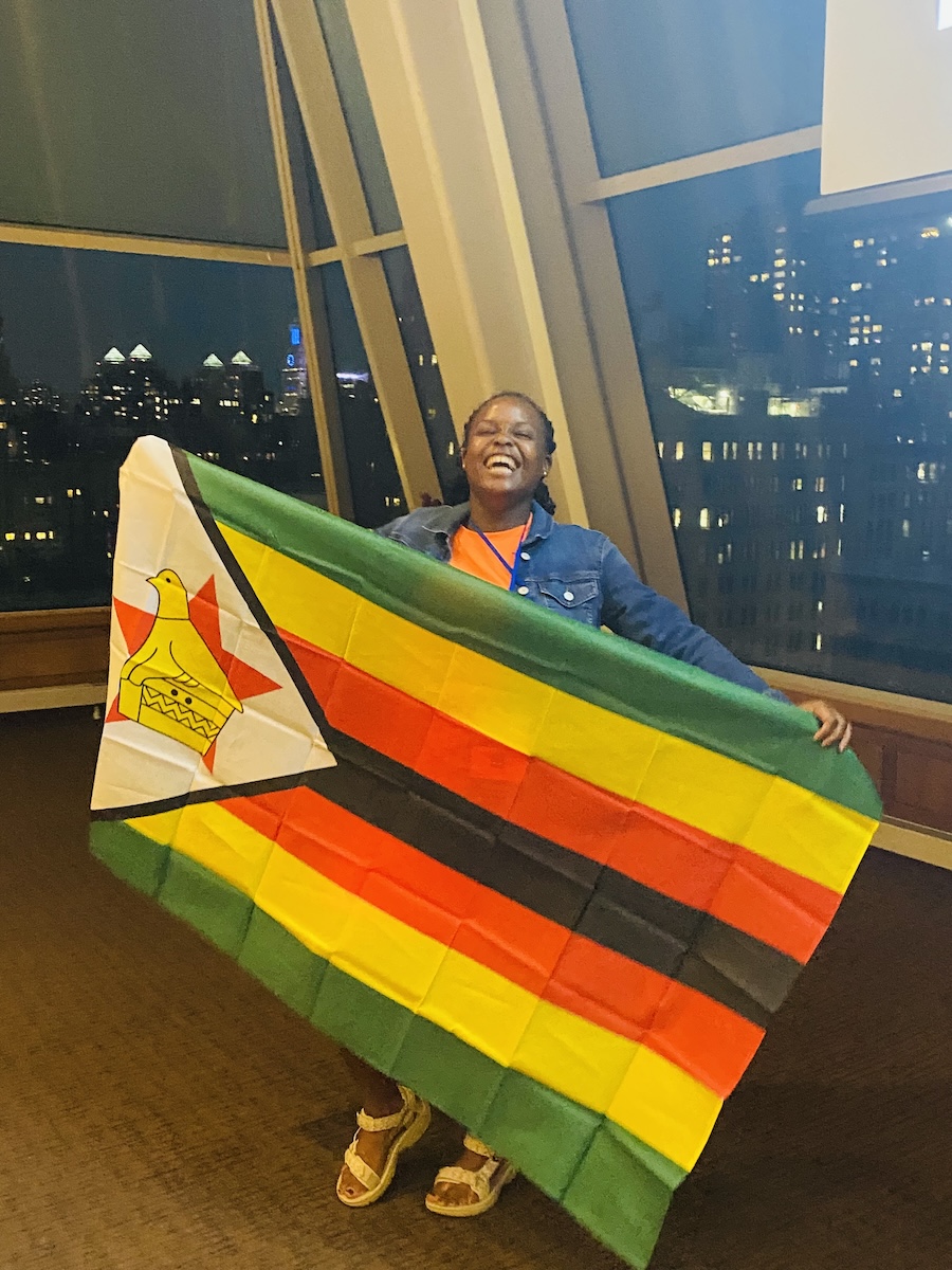 Mukudzei twirls a Zimbabwean flag at the AFS Youth Assembly in New York City.