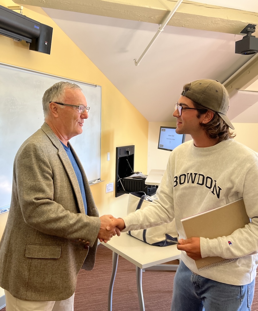 Phil Gregory shakes hands with a student