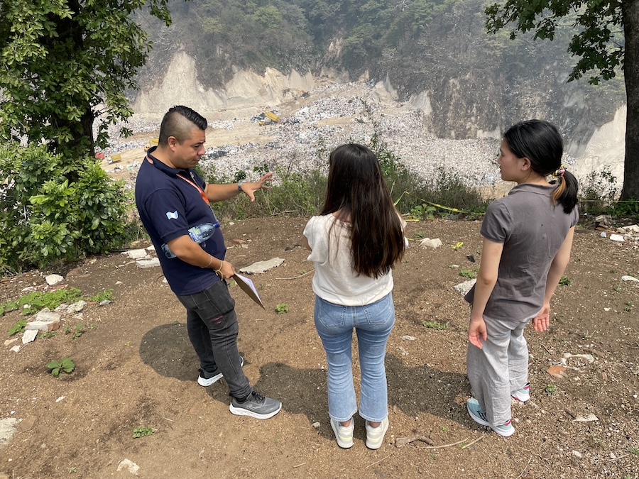 Three people stand in front of the landfill. Photo submitted by the McKeen Center.