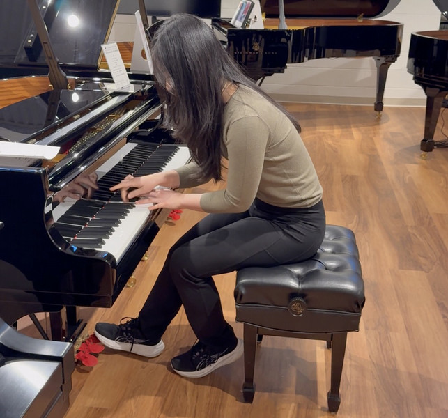 student tries piano at steinway showroom boston