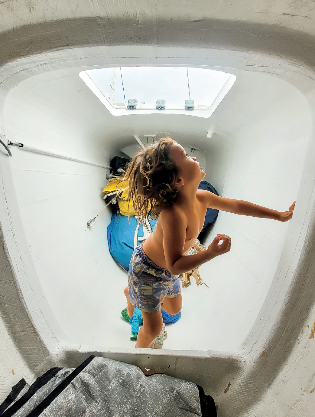 The youngest crewmember, Atlas, at four— on Christmas Day 2024—inside one of the ama compartments that are used for storage but double as in-port berths and playgrounds.