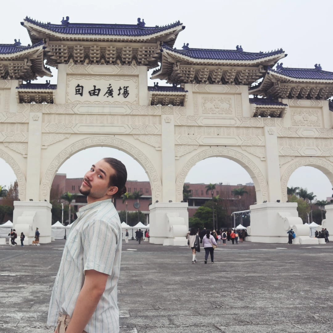 Student in front of ornate building gate in Taiwan