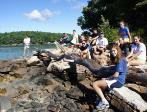 students hanging on rocks by the water