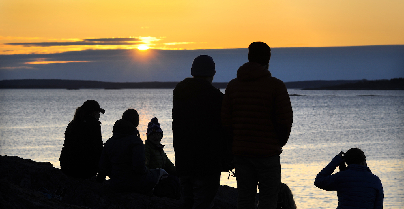 students silhouettes looking out on the horizon