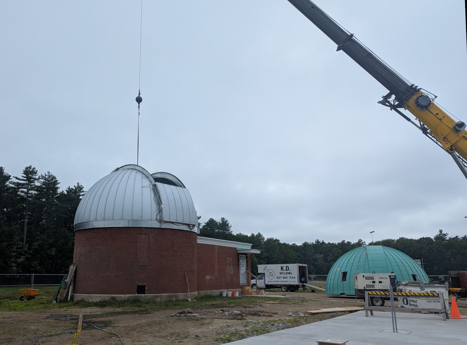 The new dome in place on the observatory, with the crane lifting equipment into the dome.