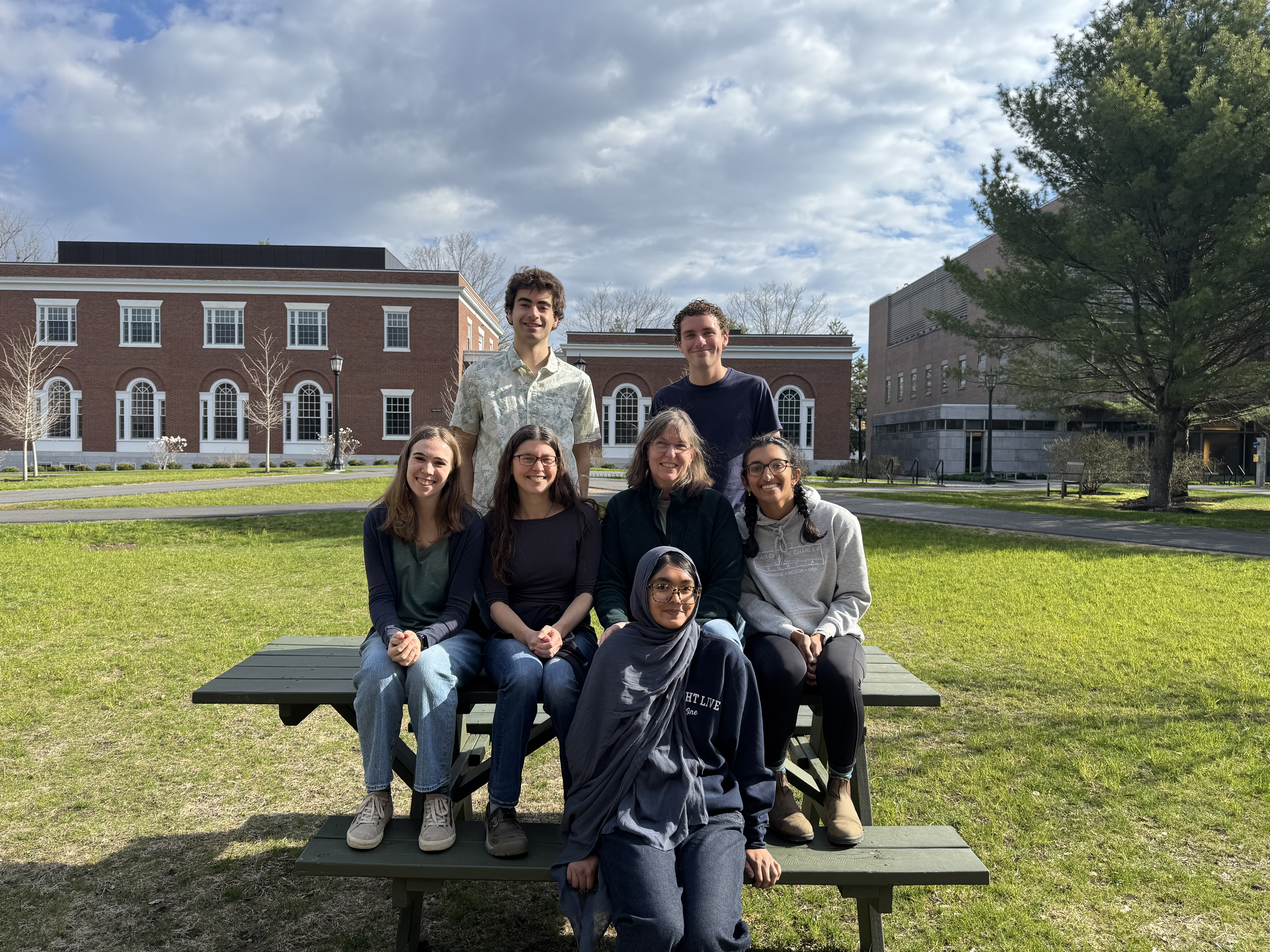 Dube lab on a picnic table outside in Spring 2026