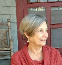 June Vail standing in front of large window