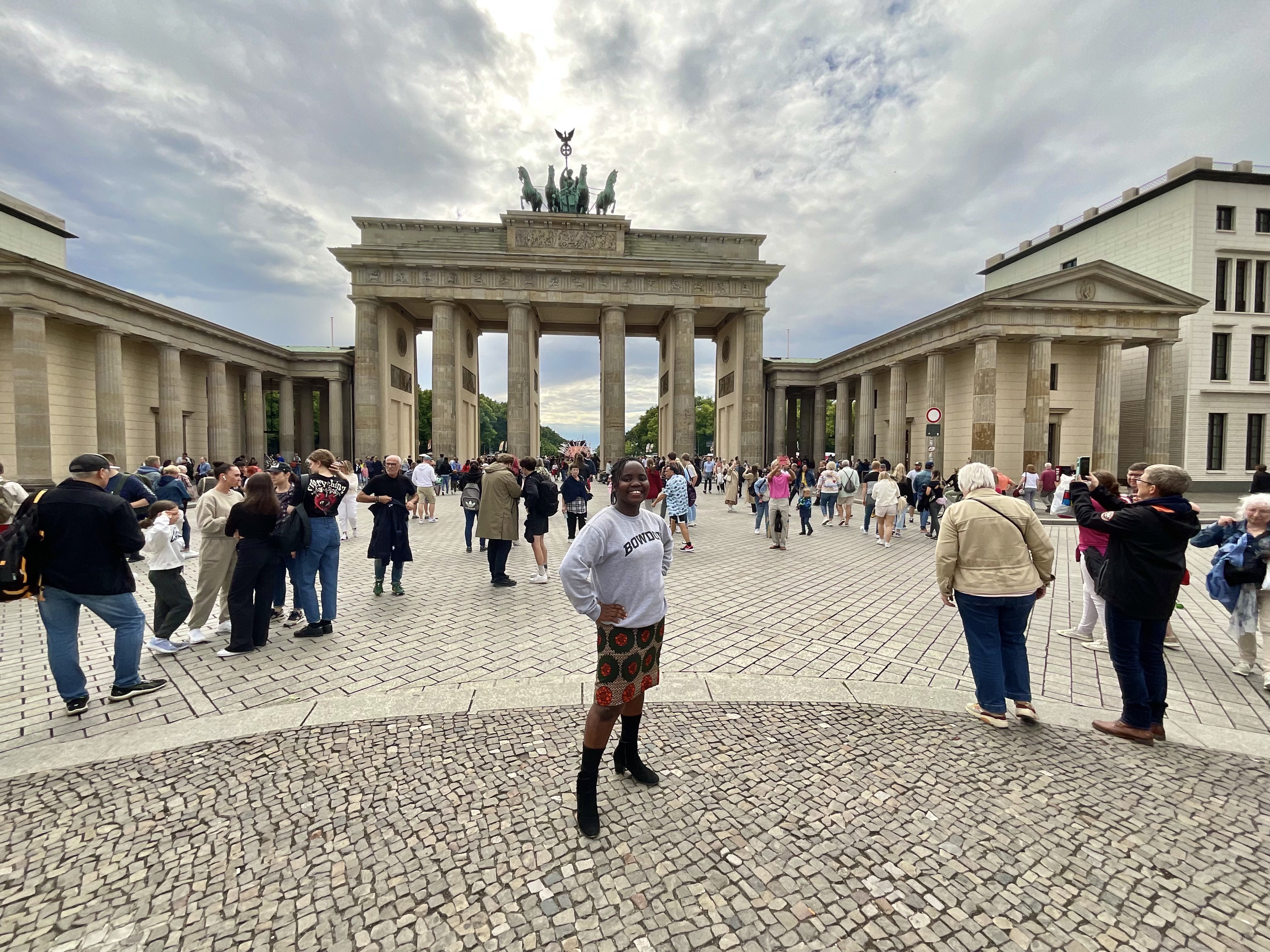 Student stands in front of Brandenburg Gate in Berlin
