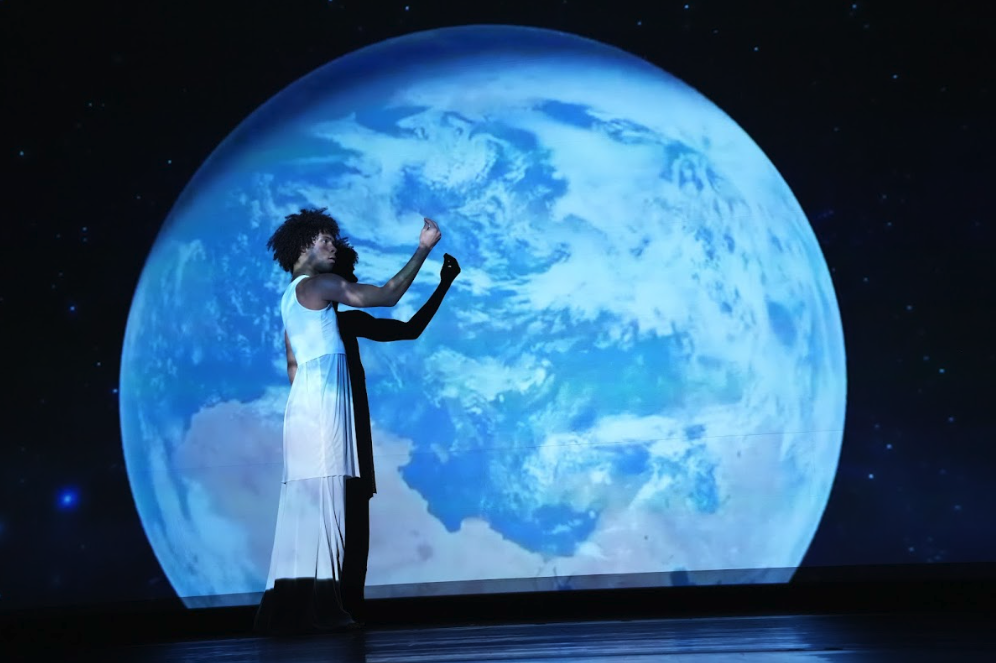 Student in front of video projection of the moon.