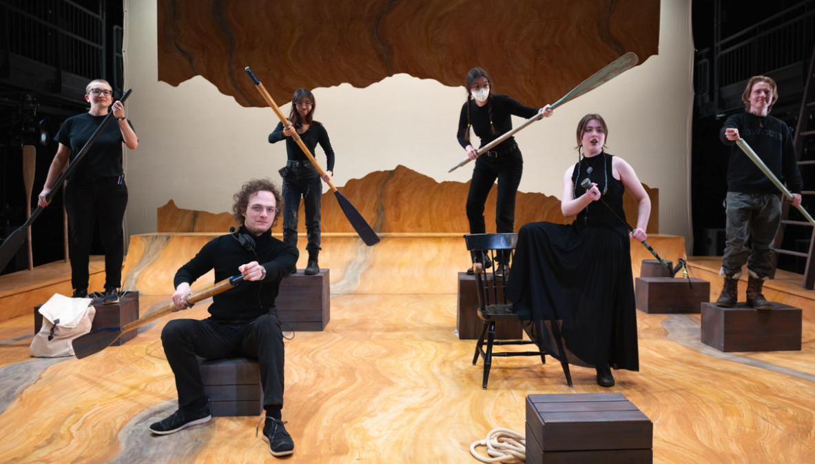 Crew of play, posing on boxes.