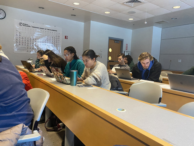 Students review documents while working on their computers